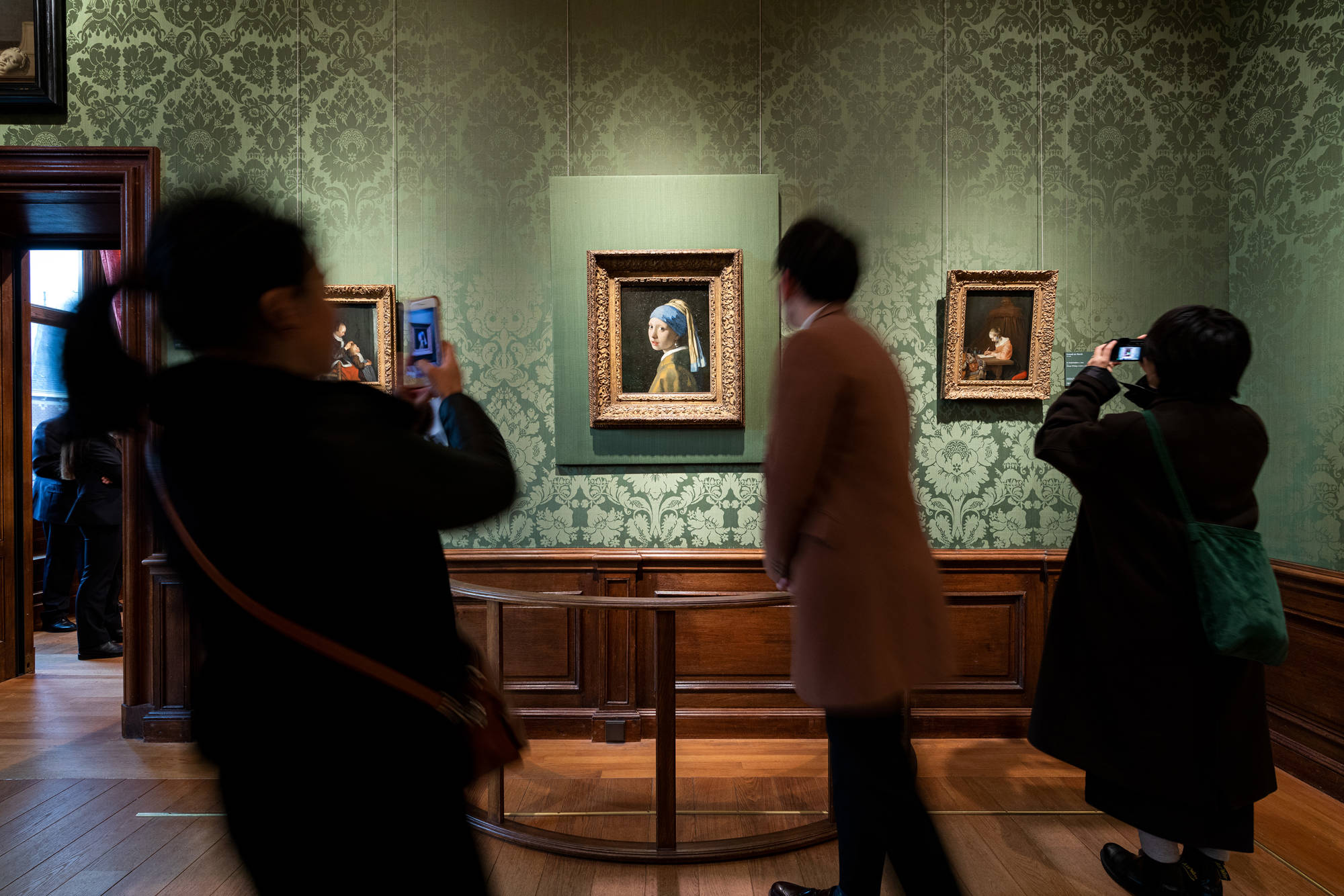 Bezoekers van het Mauritshuis staan stil voor 'Meisje met de parel' van Johannes Vermeer